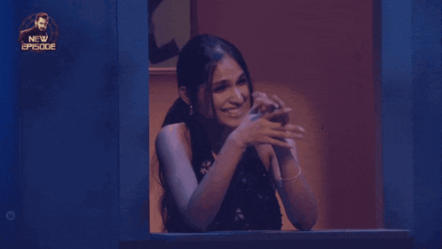 a woman laughs while looking out of a window with a new episode logo behind her