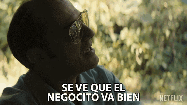 a man wearing glasses says " se ve que el negocio va bien "