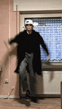a man wearing a hat and sunglasses is jumping in the air
