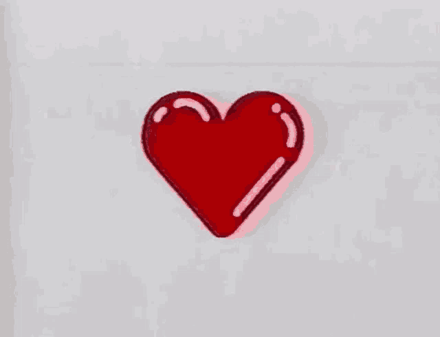 a red heart is floating in the air on a white background .