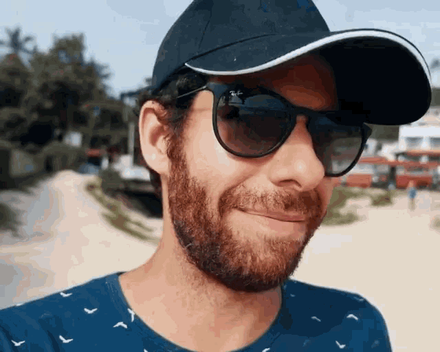 a man with a beard wearing a hat and sunglasses
