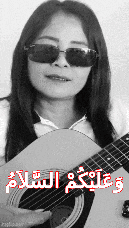 a woman wearing sunglasses is holding an acoustic guitar with arabic writing on it