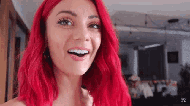 a woman with red hair is smiling in a living room .