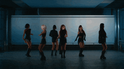 a group of women are dancing in front of a white wall