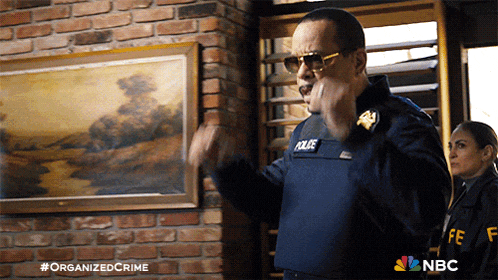 a man in a police uniform is standing in front of a painting