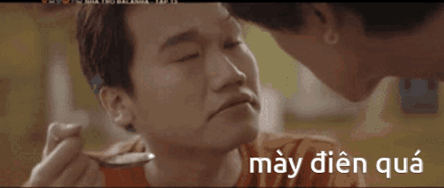 a man with a spoon in his hand looks at another man with the words may dien qua written below him