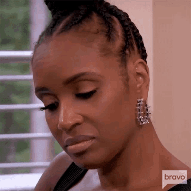 a close up of a woman 's face with a bravo logo in the background