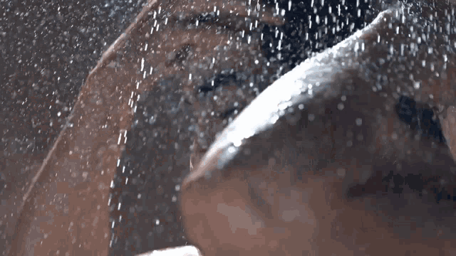 a man is taking a shower and the water is falling on him
