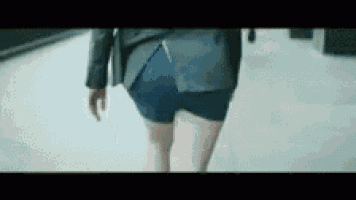 a woman wearing shorts and a jacket is walking down a street .