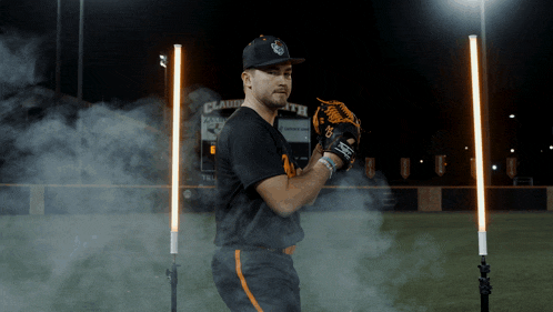 a baseball player is standing in front of a scoreboard that says clarksville
