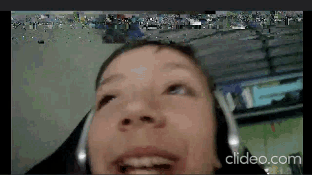 a close up of a person wearing headphones with clideo.com in the bottom right corner