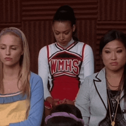 a cheerleader wearing a wmhs uniform sits in a classroom