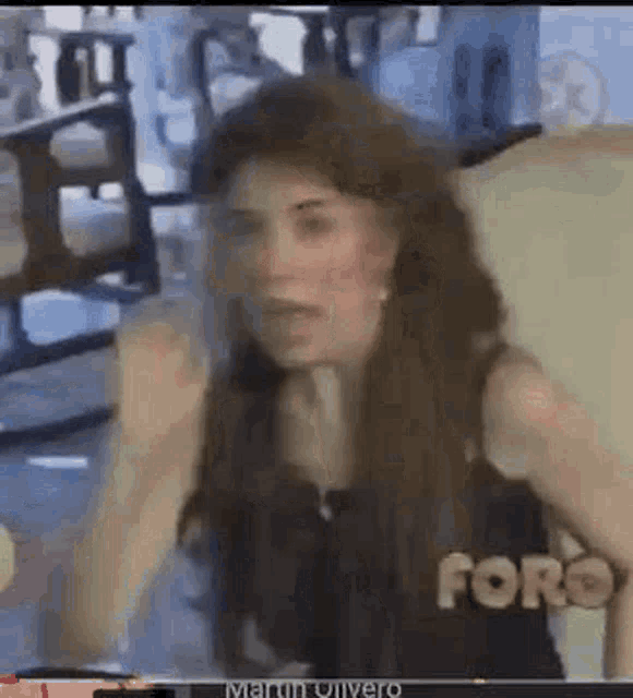 a woman is giving a fist bump while sitting in a chair in a living room .