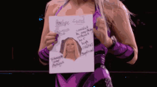 a woman in a purple and black outfit is holding a piece of paper with a picture of a blonde woman on it