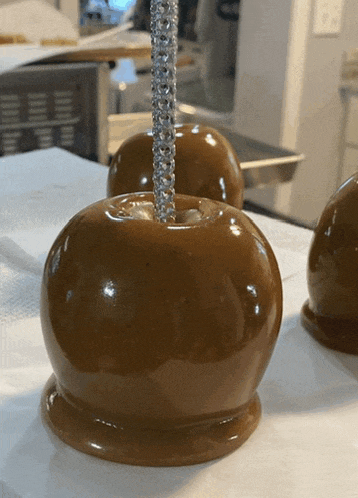a close up of a caramel apple with a silver stick sticking out of it