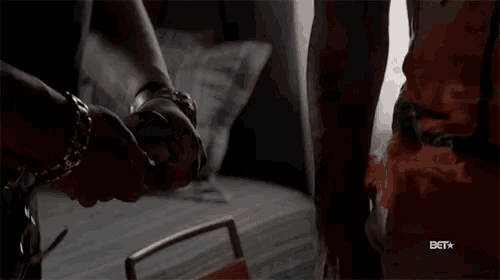 two people holding hands in a dark room with a bet logo on the bottom