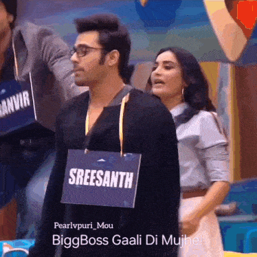 a man with a sign that says sreesanth is standing next to a woman