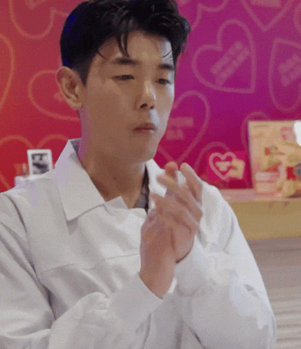 a man wearing a white shirt is clapping his hands