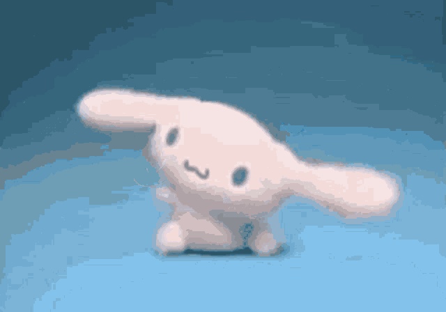 a stuffed bunny is dancing on a blue surface .