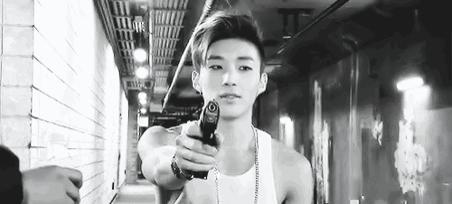 a young man is holding a gun in a hallway .