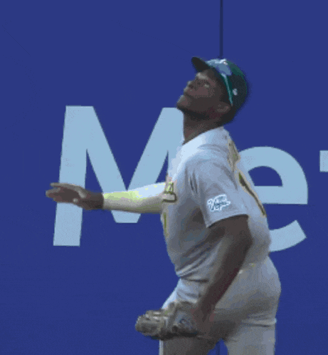 a baseball player catches a ball in front of a sign that says " home "