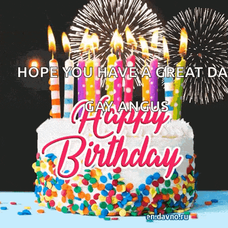 a birthday cake with candles and fireworks behind it