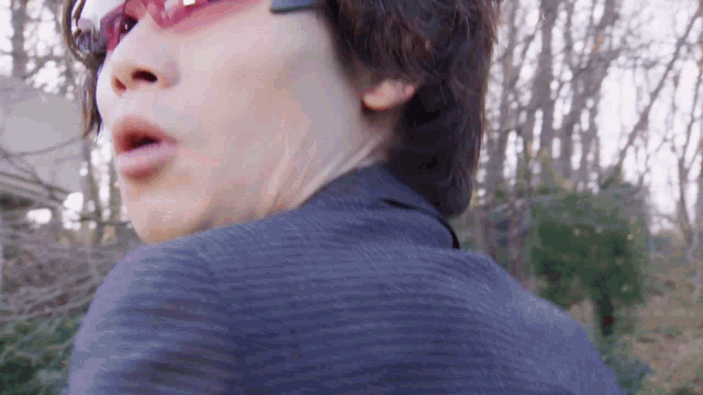a close up of a person wearing sunglasses and a blue jacket