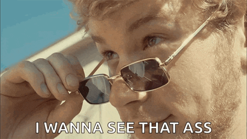 a man wearing sunglasses has the words i wanna see that ass below him