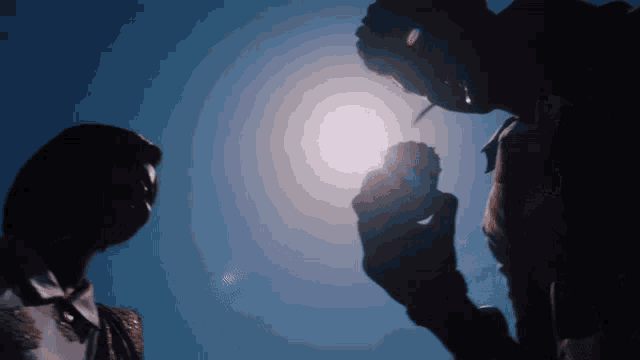 a man and a woman are standing in front of a bright sun