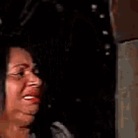 a woman with a flower in her hair is crying and holding a stick
