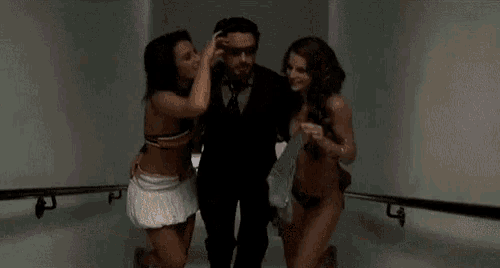 a man and two women are standing next to each other in a room .
