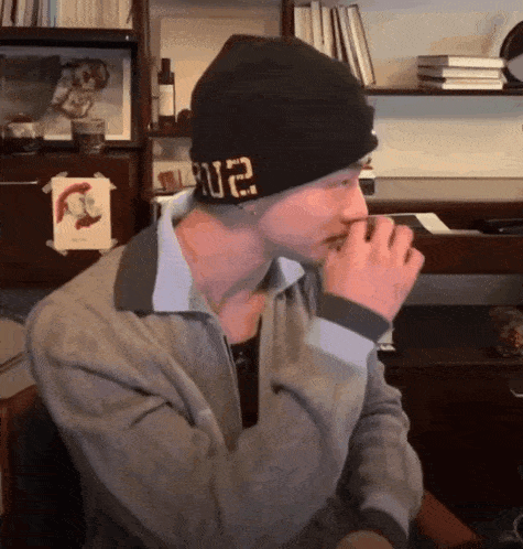 a man wearing a black beanie with the letters u2 on it