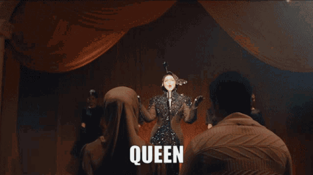 a woman in a white dress with the word queen written on it