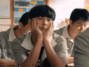 a boy with his hands on his face is wearing a shirt that says ' pi ' on it