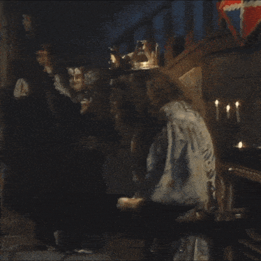 a man with a beard and a crown on his head is standing in a dark room