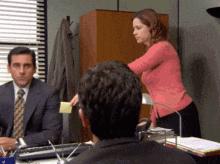 a woman in a pink shirt is standing next to a man in a suit