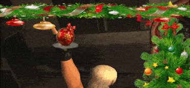 a person is holding a christmas ornament in their hand in front of a christmas tree