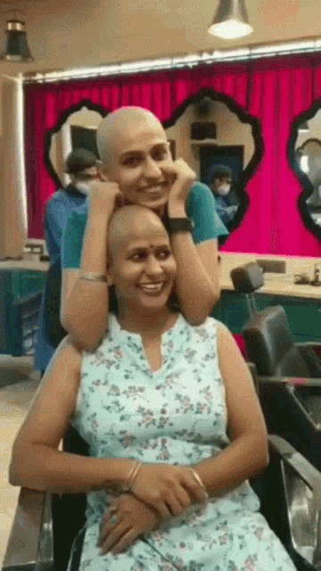 a woman with a shaved head sits next to a man
