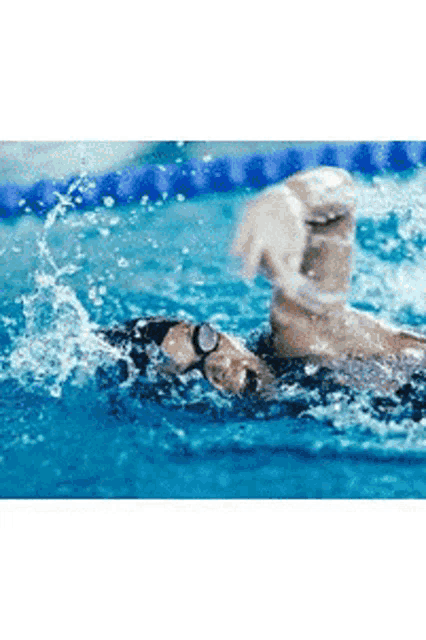 a person is swimming in a swimming pool with goggles on .