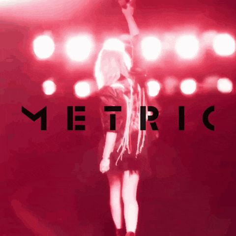 a woman stands in front of a red background with the word metric on it