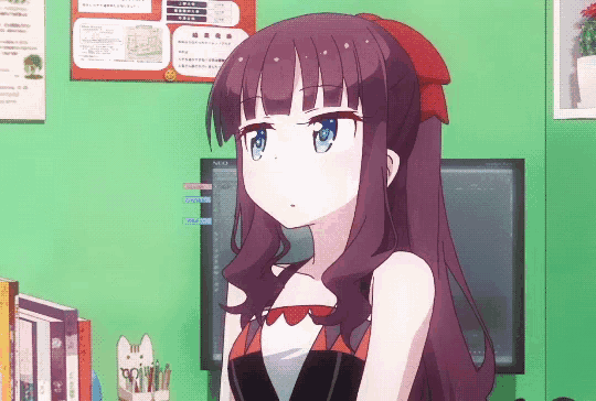 a girl with purple hair and blue eyes is sitting in front of a computer monitor