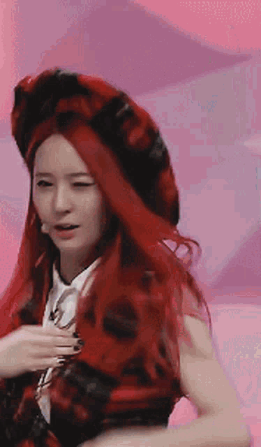 a woman with red hair is wearing a red plaid hat
