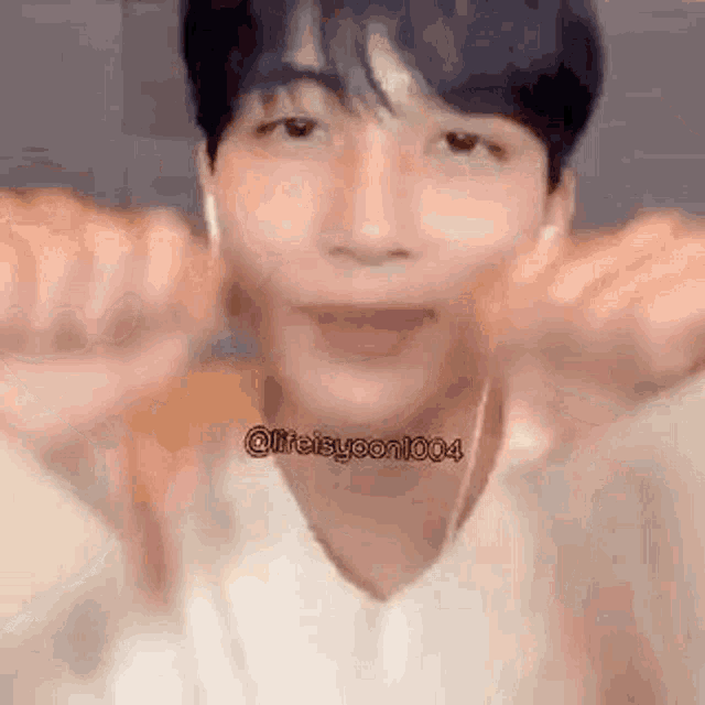 a close up of a person making a funny face with their hands in front of their face .