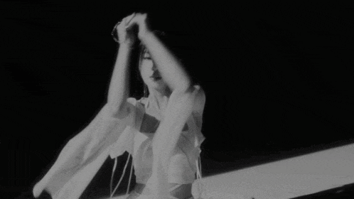 a black and white photo of a woman in a white top