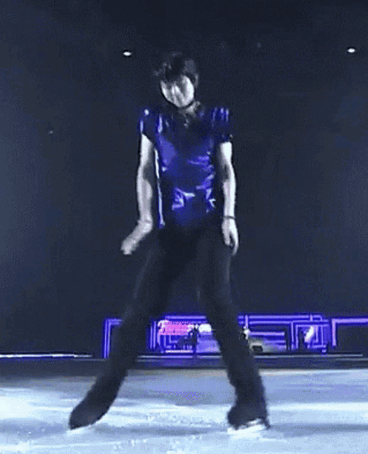 a man in a blue shirt and black pants is skating on the ice
