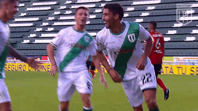 a group of soccer players are holding hands on a field