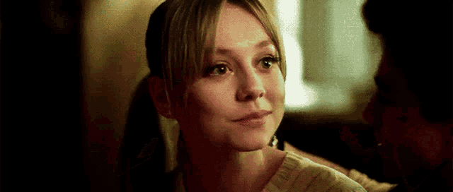 a close up of a woman 's face with a man behind her looking at her .