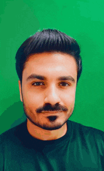 a man with a beard and mustache wearing a black shirt is smiling in front of a green background .