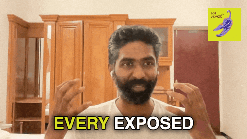 a man with a beard says " every exposed " in front of a wardrobe
