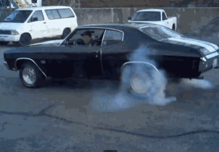 a black car with smoke coming out of it 's tires